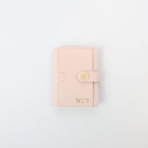 Compact card holder wallet with snap button closure and multiple card slots.