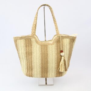Woven beach bag with braided handles and tassel charm, ideal for summer outings.