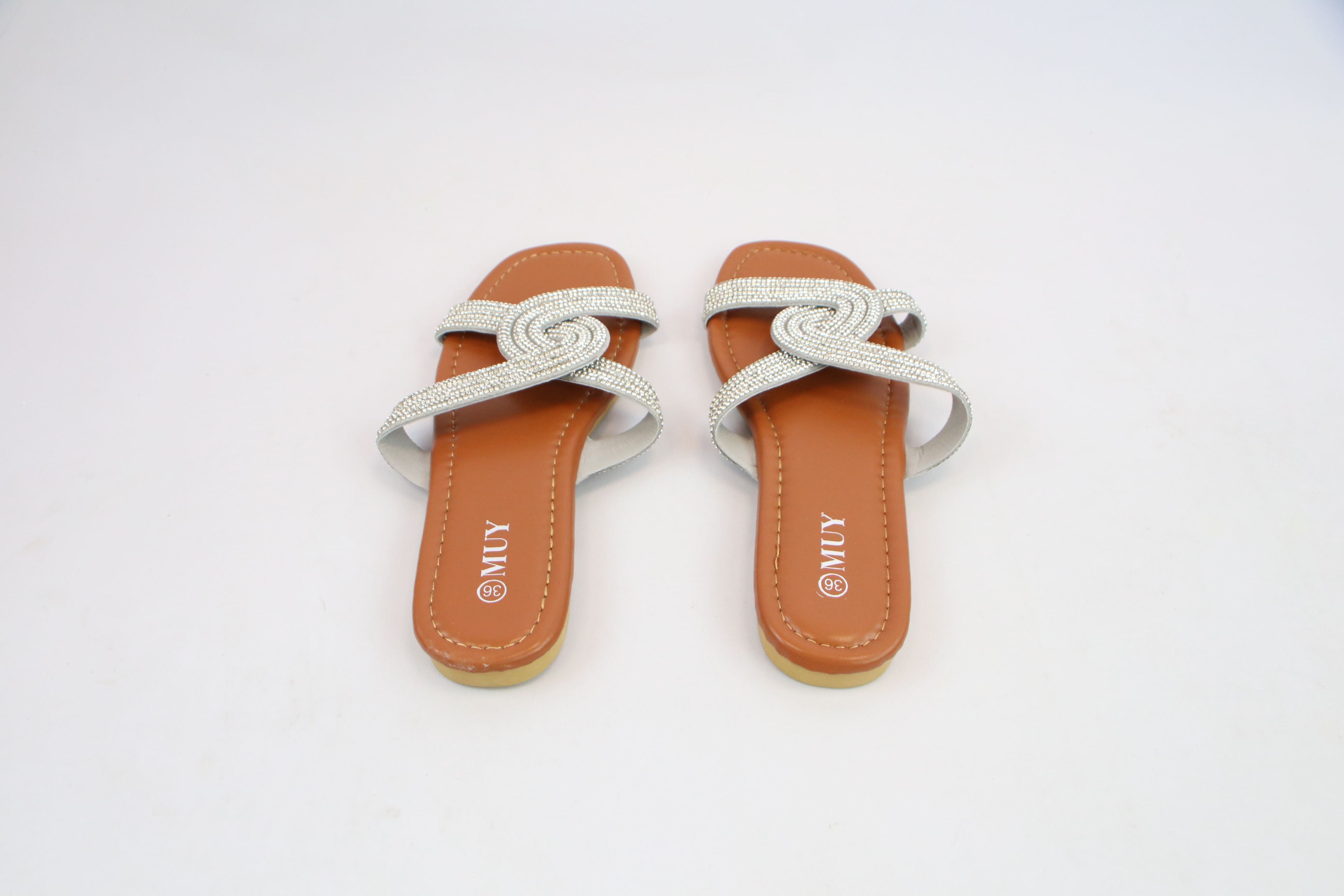 Flat sandals with crossover strap design and rhinestone detailing.