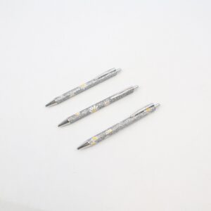 Glitter metal ballpoint pen with floral design.