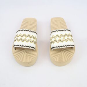 Flat slide sandals with woven strap detailing and decorative trim design.